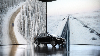 Product CGI - A car showcased in an indoor presentation area, using large digital screens depicting snowy, wooded landscapes and icy roads as the backdrop.